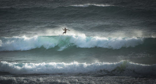 Shirtless man surfing in sea