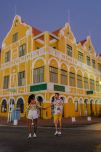 Rear view of people in front of historic building