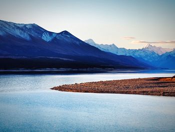 Scenic view of lake and mountains against clear sky