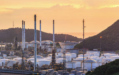 Illuminated factory against sky during sunset