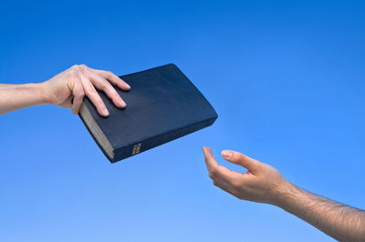 Close-up of man holding blue sky