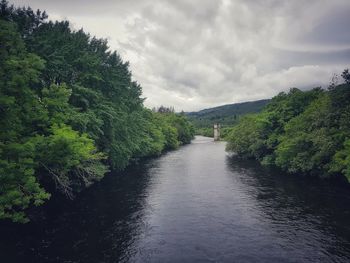 Scenic view of water amidst trees against sky