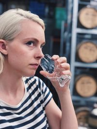 Close-up of thoughtful young woman holding wineglass