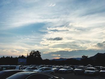 Cars on road against sky during sunset