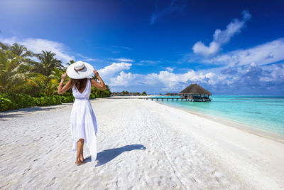 Full length of woman on beach against sky