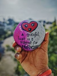Close-up of hand holding heart shape with text