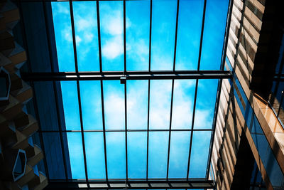 Low angle view of glass building against sky