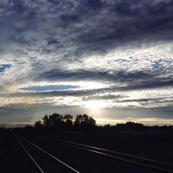 Road passing through landscape against cloudy sky