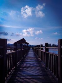 View of wooden pier over sea against sky