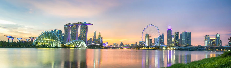 Illuminated buildings in city against sky