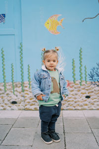 Portrait of boy standing on footpath