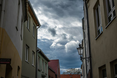 Low angle view of buildings against cloudy sky