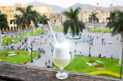 Close-up of drink on table against buildings in city