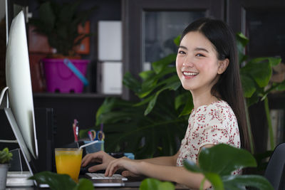 Portrait of a smiling young woman sitting at table