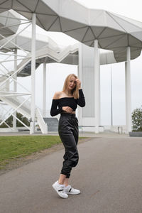 Full length of young woman standing on bus