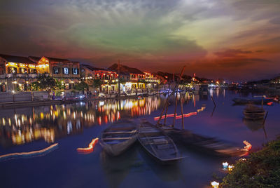 Boats moored in marina at sunset