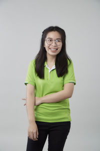 Portrait of smiling young woman against white background