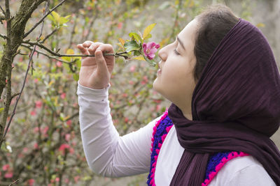 Side view of woman holding pink flowering plants