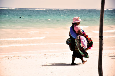 Rear view of woman walking on beach