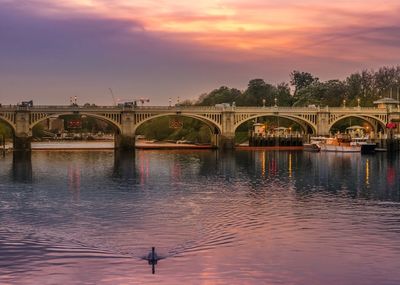 Bridge over river against cloudy sky