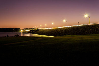 Illuminated street lights against clear sky at night