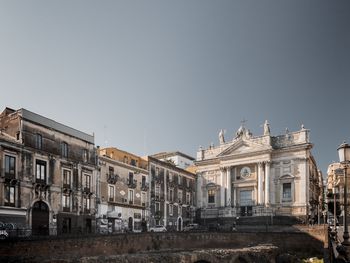 Low angle view of old buildings and church against clear sky. photo taken in catania, sicily, italy 