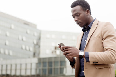 Businessman using smart phone in city