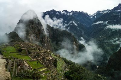 High angle view of machu picchu by mountains during foggy weather