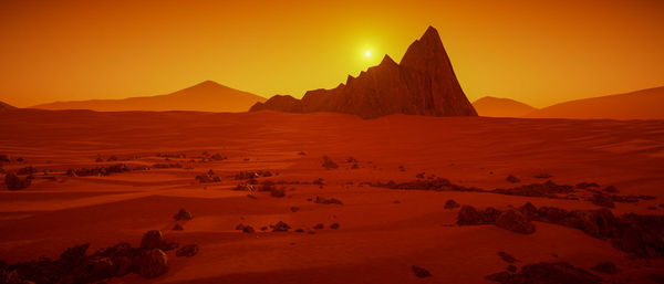 Scenic view of desert against sky during sunset