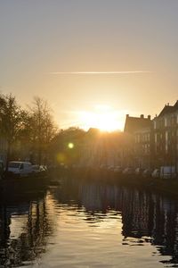Boats in lake against sky during sunset