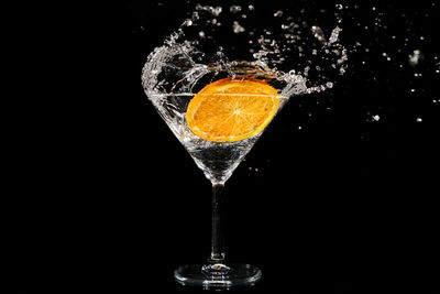 Close-up of drink on glass against black background