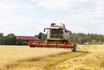 Combine harvester harvesting crop in field