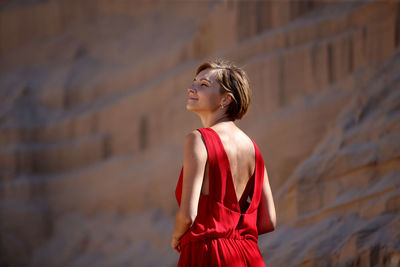 Young woman standing against rock formations