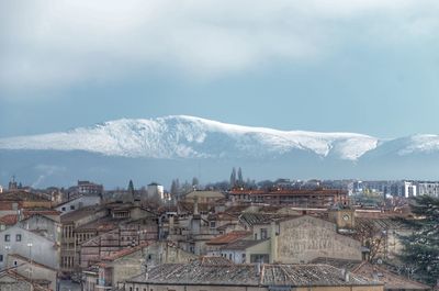 View of cityscape against cloudy sky