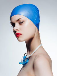 Portrait of a young woman against blue background