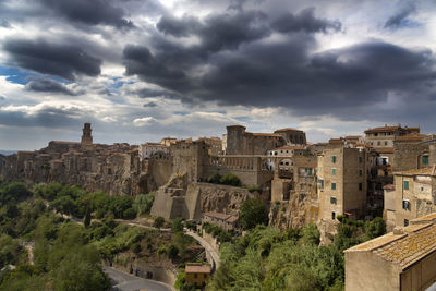 Buildings in city against cloudy sky