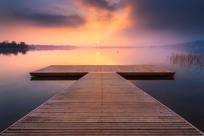 Pier over sea against sky during sunset