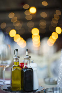 Close-up of drink in bottles against illuminated lights