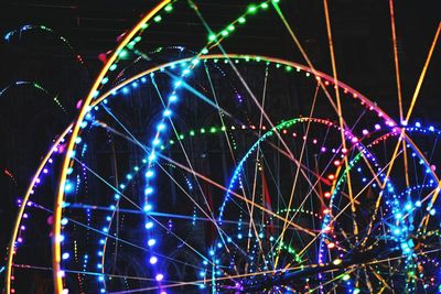 Low angle view of illuminated ferris wheel against sky at night