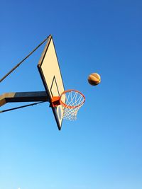 Low angle view of basketball hoop against clear blue sky