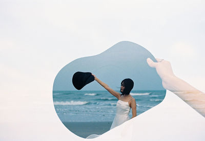 Cropped hand of person holding photograph against white background