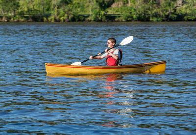 Man sitting in boat on lake