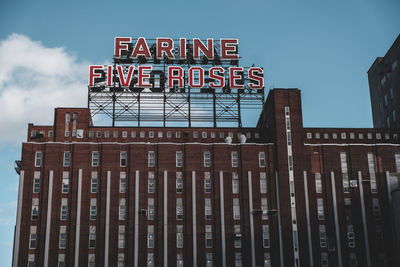 Low angle view of text on building against sky