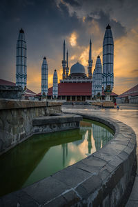 Reflection of temple in city at sunset