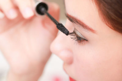 Close-up of woman applying mascara