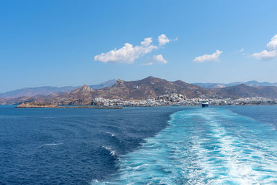 Scenic view of sea and mountains against blue sky