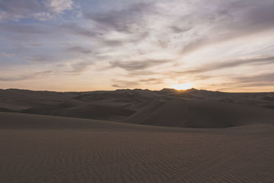 View of sand dunes in desert at dusk