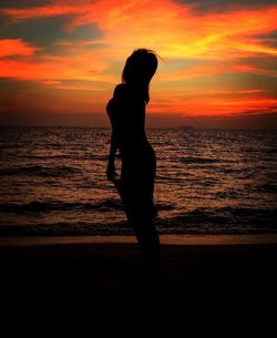 Silhouette of people on beach at sunset