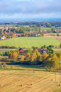 Scenic view of agricultural field against buildings