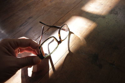 High angle view of hand holding eyeglasses